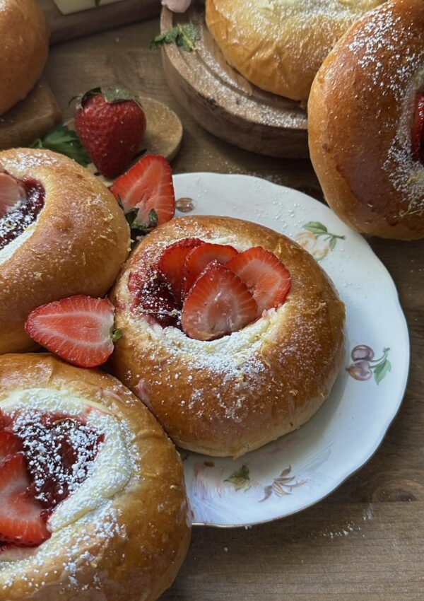 Strawberry cheesecake brioche, freshly baked and ready to eat, with a soft, fluffy texture topped with sweet strawberry filling and creamy cheesecake