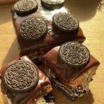 Delicious No-Bake Oreo Cheesecake Bars, ready to eat with a smooth, creamy filling and a crunchy Oreo crust, topped with ganache and Oreos for extra flavor