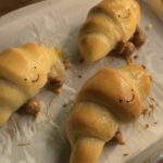 Freshly baked Jellycat croissant, golden brown and ready to eat, with a flaky, buttery texture